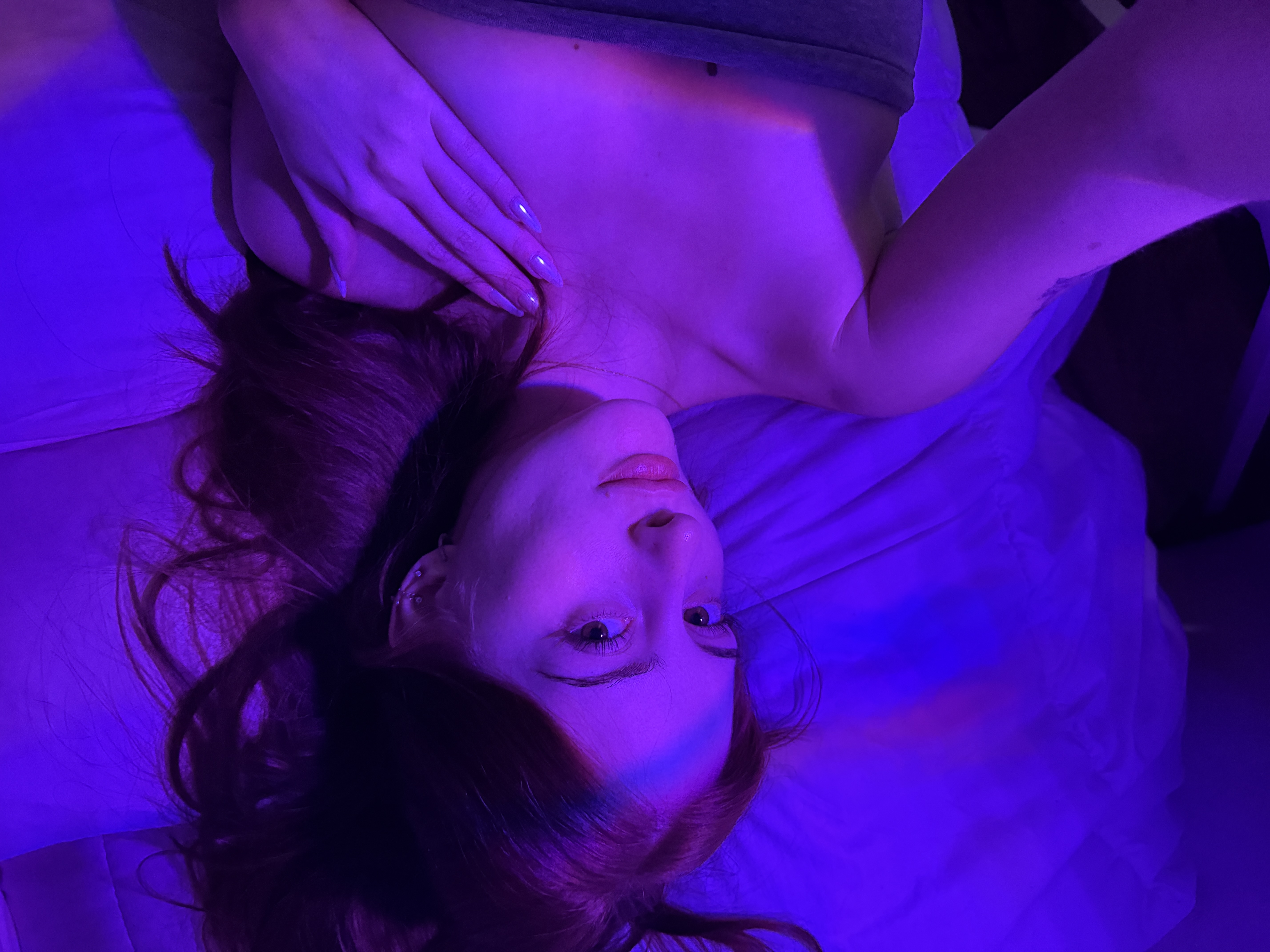 Maria resting under soft purple neon lighting